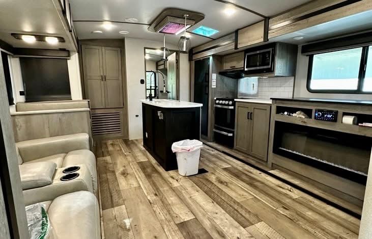 Trailer living area with sofa, kitchen island and fireplace