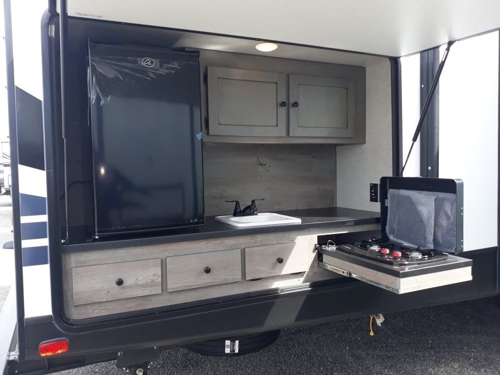 Outdoor kitchen compartment with refrigerator, sink and pull-out cooktop